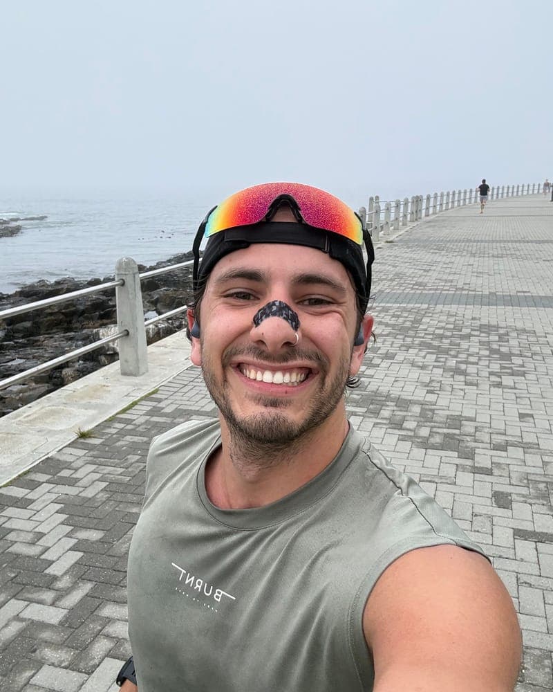 Runner on a seaside promenade wearing a RestUp nasal strip