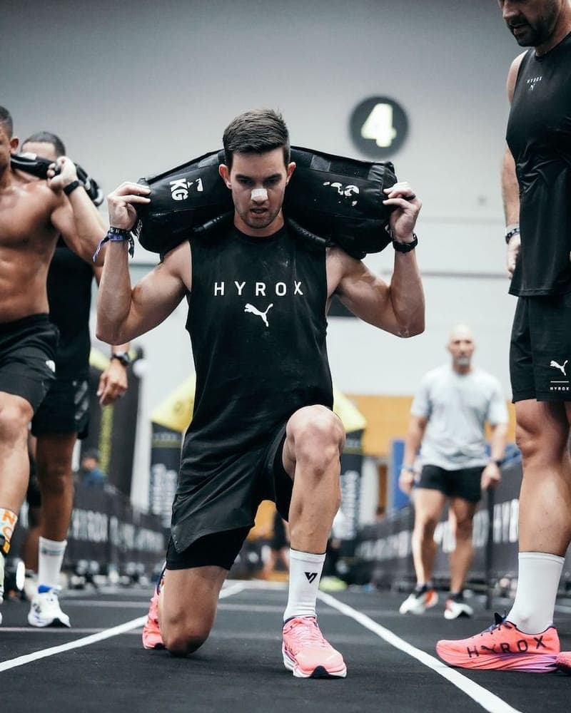 Athlete wearing a RestUp nasal strip during HYROX sandbag lunges